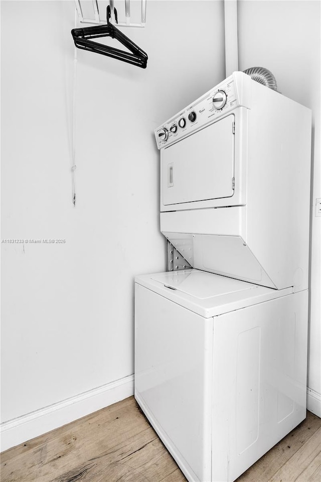 495 SE Brickell Ave Unit 1511, Miami, FL 33131 - washroom featuring stacked washing machine and dryer and light wood-style floors