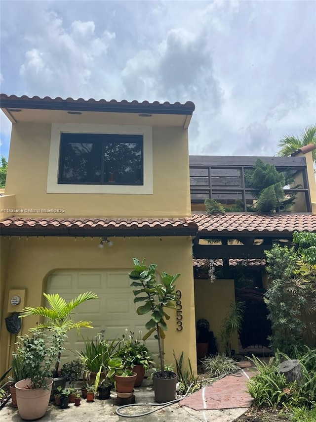 9853 Costa Del Sol Blvd Unit 103-F, Doral, FL 33178 - back of property with an attached garage, a tile roof, and stucco siding