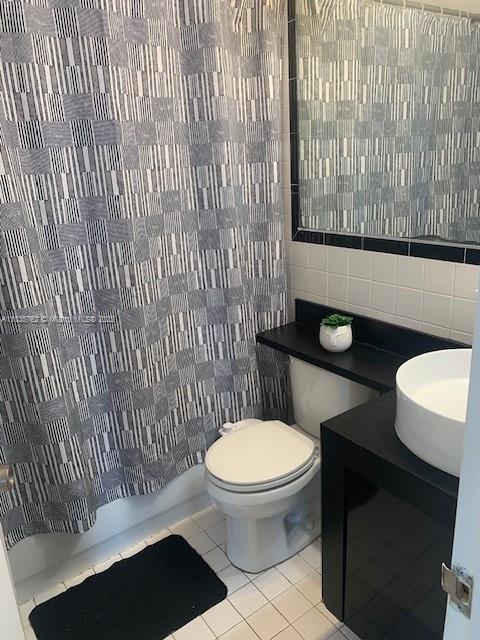 1244 Pennsylvania Ave Unit 306, Miami Beach, FL 33139 - half bathroom featuring tile walls, tile patterned flooring, tasteful backsplash, and vanity