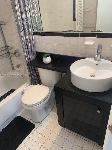 1244 Pennsylvania Ave Unit 306, Miami Beach, FL 33139 - bathroom with tile walls, vanity, shower / bath combo with shower curtain, and tile patterned floors
