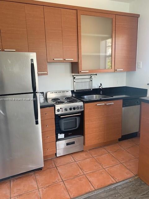1244 Pennsylvania Ave Unit 306, Miami Beach, FL 33139 - kitchen featuring appliances with stainless steel finishes, dark countertops, and light tile patterned floors