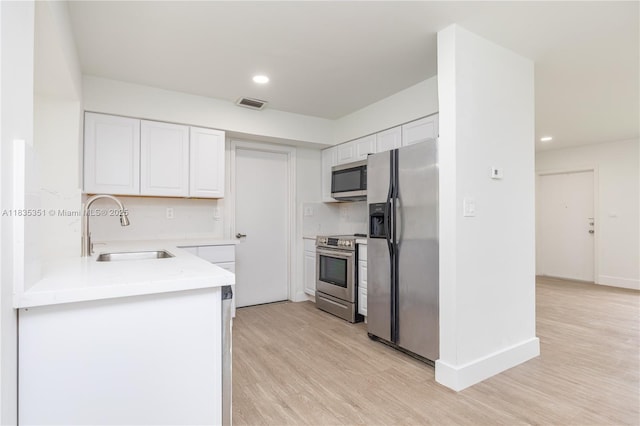 4516 Mainland Dr, Tamarac, FL 33319 - kitchen with stainless steel appliances, white cabinetry, light wood-type flooring, light countertops, and recessed lighting