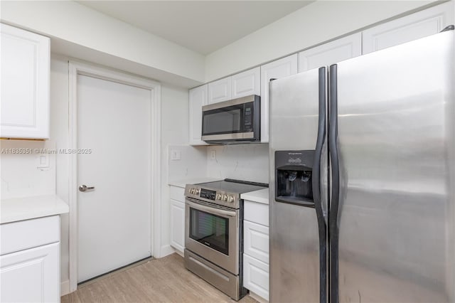 4516 Mainland Dr, Tamarac, FL 33319 - kitchen with stainless steel appliances, light wood-type flooring, light countertops, and white cabinets
