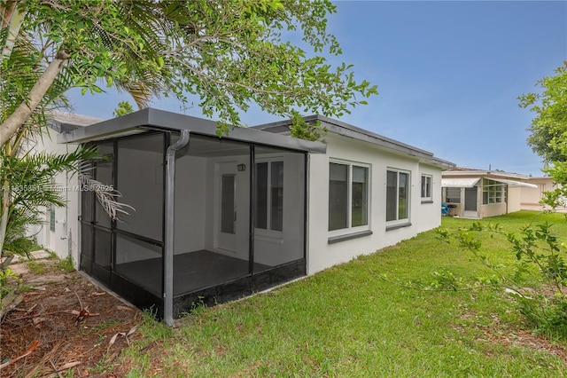 4516 Mainland Dr, Tamarac, FL 33319 - rear view of house with a sunroom, a lawn, and stucco siding