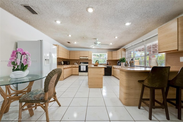 4235 SW 97th Ave, Miami, FL 33165 - kitchen featuring white appliances, a textured ceiling, a peninsula, light brown cabinets, and under cabinet range hood