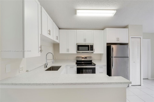 653 NW San Remo Cir, Port St Lucie, FL 34986 - kitchen with stainless steel appliances, a peninsula, light stone counters, light tile patterned floors, and white cabinets