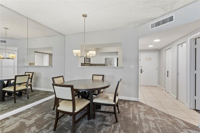 17375 Collins Ave Unit 1004, Sunny Isles Beach, FL 33160 - dining room featuring carpet floors, a textured ceiling, and a chandelier