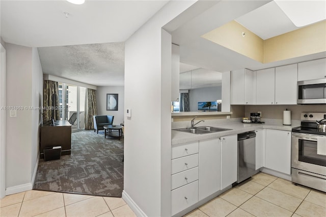 17375 Collins Ave Unit 1004, Sunny Isles Beach, FL 33160 - kitchen with appliances with stainless steel finishes, light tile patterned floors, light countertops, light colored carpet, and white cabinets