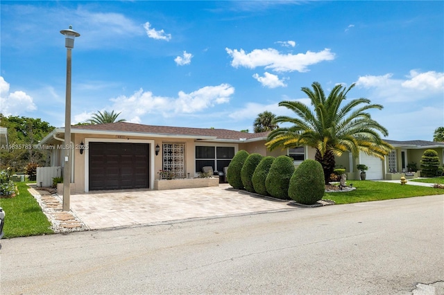 4811 NW 58th St, Tamarac, FL 33319 - ranch-style house with an attached garage, driveway, stucco siding, and a front yard