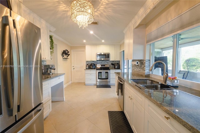 4811 NW 58th St, Tamarac, FL 33319 - kitchen with appliances with stainless steel finishes, crown molding, tasteful backsplash, light tile patterned flooring, and white cabinetry