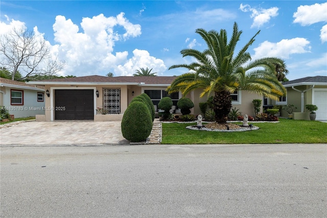 4811 NW 58th St, Tamarac, FL 33319 - ranch-style house featuring driveway, a garage, stucco siding, and a front yard