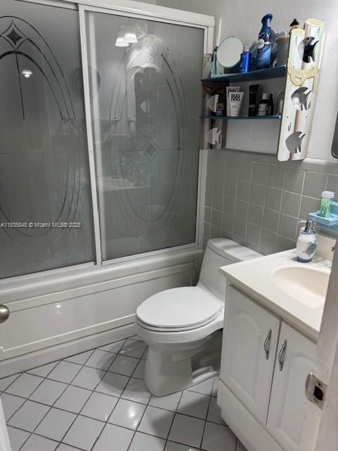 6424 SW 20th St, Miramar, FL 33023 - bathroom featuring vanity, bath / shower combo with glass door, tile walls, and tile patterned flooring