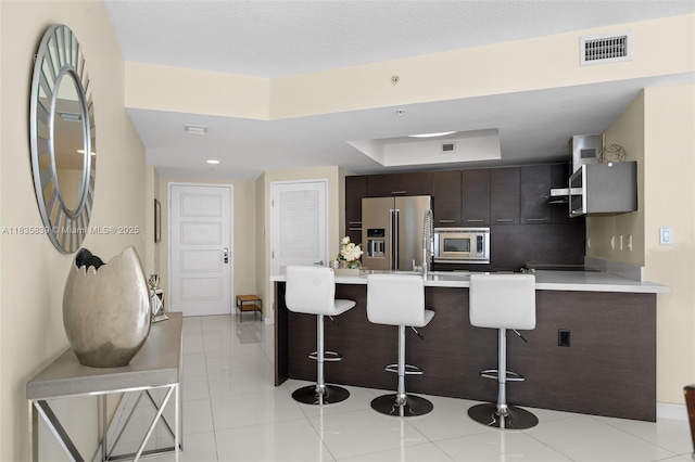 150 Sunny Isles Blvd Unit 1-1401, Sunny Isles Beach, FL 33160 - kitchen featuring appliances with stainless steel finishes, a breakfast bar area, modern cabinets, a peninsula, and light countertops