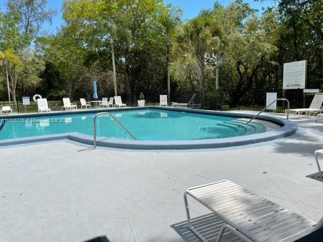17890 W Dixie Hwy Unit 219, Miami, FL 33160 - community pool featuring a patio and view of wooded area
