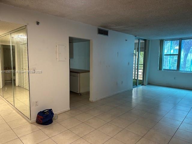 17890 W Dixie Hwy Unit 219, Miami, FL 33160 - spare room featuring a textured ceiling and light tile patterned floors