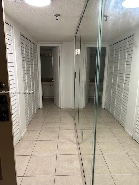 17890 W Dixie Hwy Unit 219, Miami, FL 33160 - corridor with light tile patterned floors and a textured ceiling