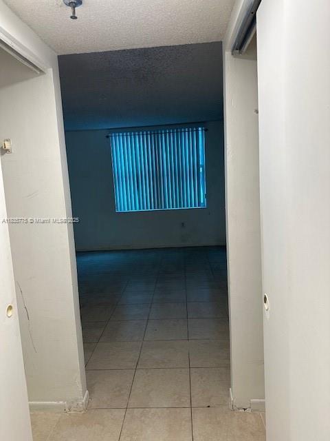 17890 W Dixie Hwy Unit 219, Miami, FL 33160 - hall with tile patterned floors and a textured ceiling