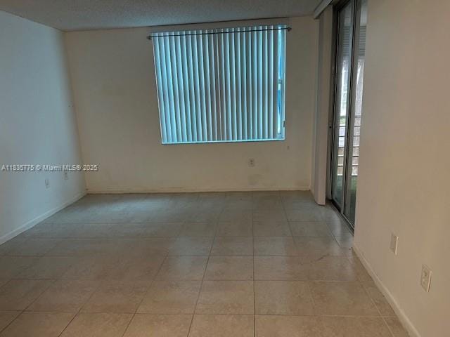 17890 W Dixie Hwy Unit 219, Miami, FL 33160 - spare room with light tile patterned floors and baseboards