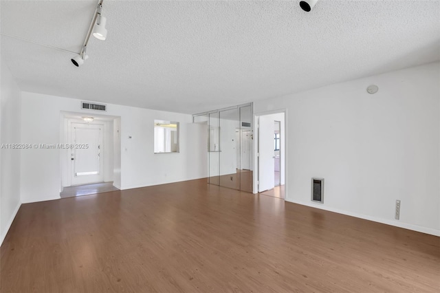7331 NW 18th St Unit 205, Margate, FL 33063 - unfurnished living room with wood finished floors, a textured ceiling, and rail lighting