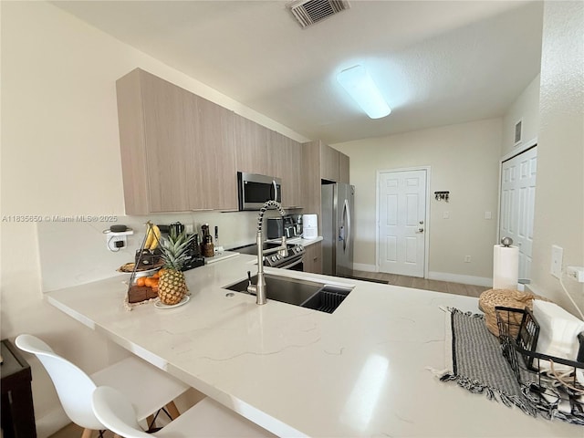 15260 SW 91st Ln, Miami, FL 33196 - kitchen featuring stainless steel appliances, a peninsula, light stone counters, light brown cabinets, and modern cabinets