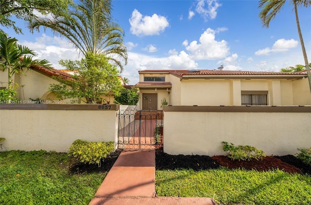 6637 NW 181st Ln, Hialeah, FL 33015 - mediterranean / spanish-style home with a fenced front yard, a gate, stucco siding, and a tiled roof