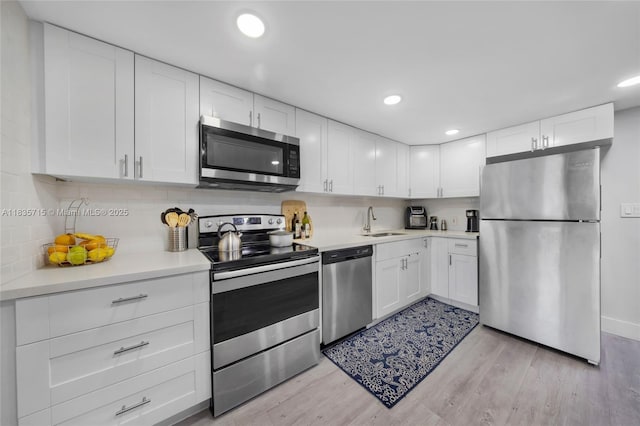 6637 NW 181st Ln, Hialeah, FL 33015 - kitchen featuring appliances with stainless steel finishes, light countertops, white cabinets, light wood-style flooring, and recessed lighting