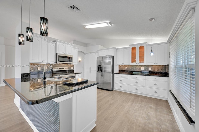 5382 NW 120th Ave, Coral Springs, FL 33076 - kitchen with appliances with stainless steel finishes, lofted ceiling, a textured ceiling, decorative backsplash, and a peninsula