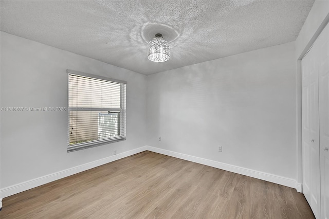 5382 NW 120th Ave, Coral Springs, FL 33076 - empty room with wood finished floors, a textured ceiling, and a chandelier