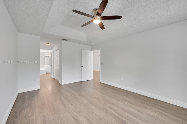 5382 NW 120th Ave, Coral Springs, FL 33076 - empty room with a textured ceiling, ceiling fan, wood finished floors, and a tray ceiling