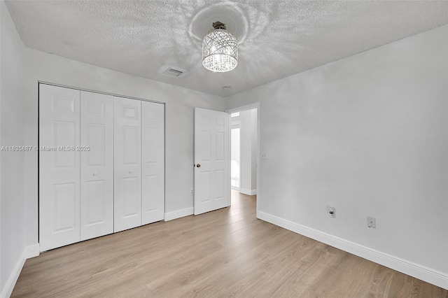 5382 NW 120th Ave, Coral Springs, FL 33076 - unfurnished bedroom featuring light wood-style flooring, a textured ceiling, a closet, and a chandelier