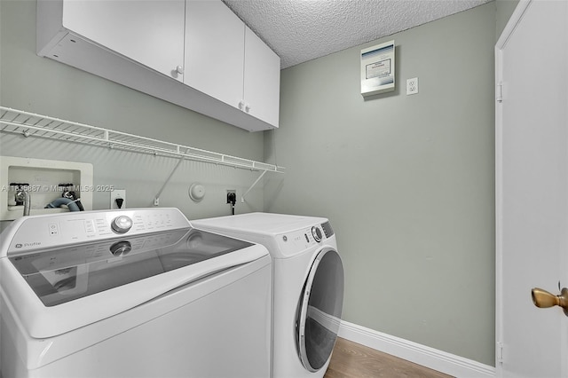 5382 NW 120th Ave, Coral Springs, FL 33076 - laundry room with cabinet space, separate washer and dryer, a textured ceiling, and wood finished floors