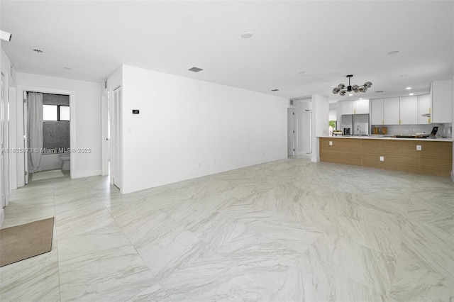 500 NW 7th Ct, Hallandale Beach, FL 33009 - unfurnished living room with a chandelier and baseboards