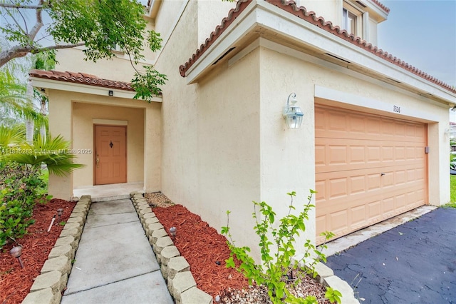 1326 Majesty Ter, Weston, FL 33327 - view of exterior entry with stucco siding, a tile roof, and a garage