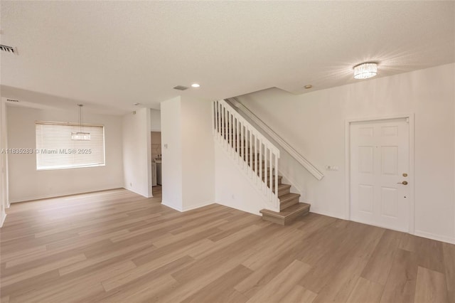 1326 Majesty Ter, Weston, FL 33327 - unfurnished living room featuring stairs, light wood-style floors, recessed lighting, and a textured ceiling