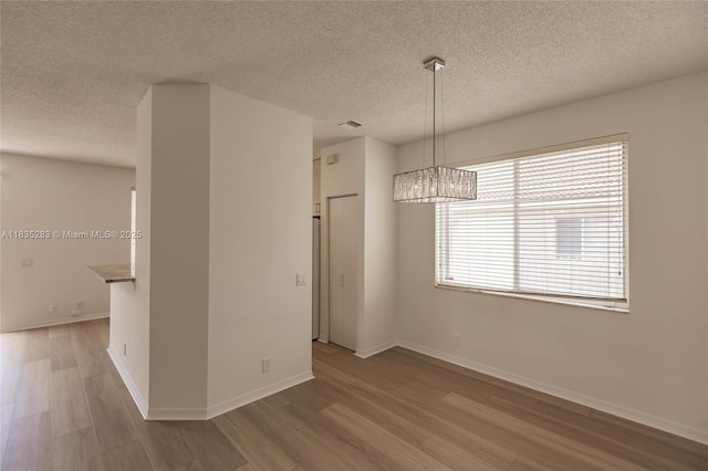 1326 Majesty Ter, Weston, FL 33327 - unfurnished dining area with a chandelier, wood finished floors, and a textured ceiling