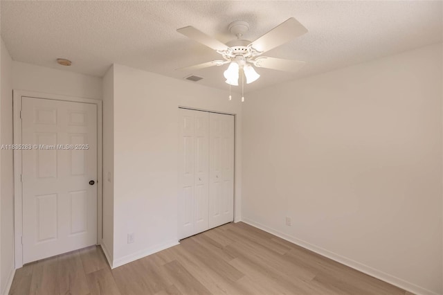 1326 Majesty Ter, Weston, FL 33327 - unfurnished bedroom featuring light wood-style flooring, a closet, a textured ceiling, and a ceiling fan