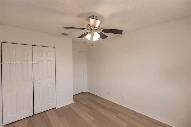 1326 Majesty Ter, Weston, FL 33327 - unfurnished bedroom featuring light wood-style floors, a textured ceiling, a closet, and a ceiling fan