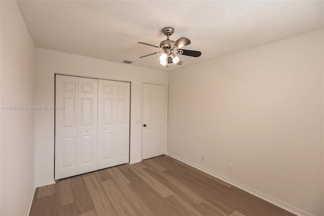 1326 Majesty Ter, Weston, FL 33327 - unfurnished bedroom featuring wood finished floors, a textured ceiling, a closet, and a ceiling fan