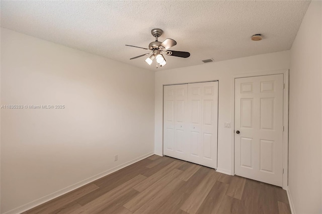 1326 Majesty Ter, Weston, FL 33327 - unfurnished bedroom with wood finished floors, a closet, a textured ceiling, and ceiling fan