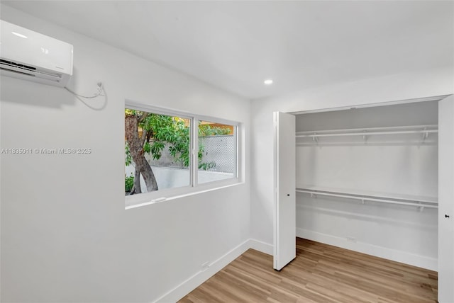 1260 SW 4th St, Miami, FL 33135 - unfurnished bedroom with a wall unit AC, wood finished floors, a closet, and recessed lighting