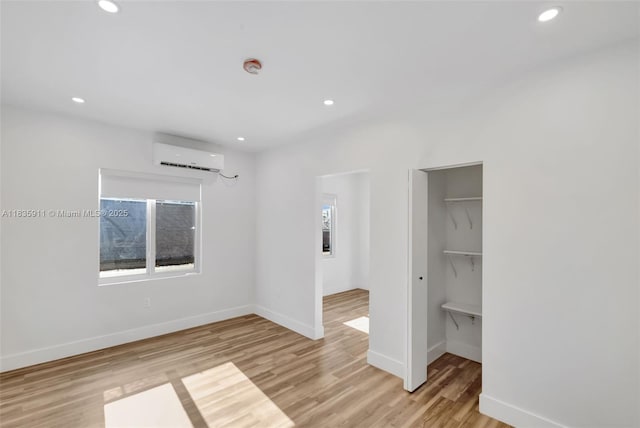 1260 SW 4th St, Miami, FL 33135 - unfurnished bedroom with light wood-style floors, a wall mounted air conditioner, recessed lighting, a closet, and a spacious closet