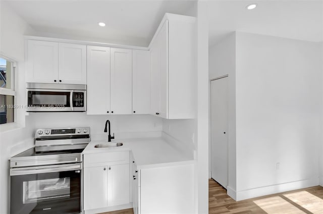 1260 SW 4th St, Miami, FL 33135 - kitchen featuring stainless steel appliances, light wood finished floors, light countertops, white cabinetry, and recessed lighting