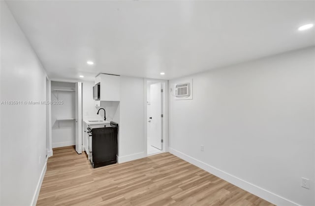 1260 SW 4th St, Miami, FL 33135 - kitchen featuring light countertops, recessed lighting, white cabinets, light wood-style floors, and a wall mounted AC