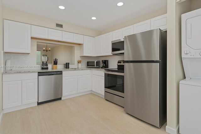 1001 Colony Point Cir Unit 419, Pembroke Pines, FL 33026 - kitchen featuring stainless steel appliances, stacked washer and clothes dryer, white cabinetry, backsplash, and recessed lighting