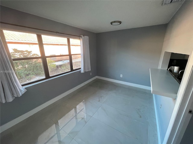 5851 W 20th Ave Unit 412, Hialeah, FL 33012 - spare room with baseboards and marble look tiles