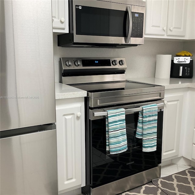 9201 Sunrise Lakes Blvd Unit 205, Sunrise, FL 33322 - kitchen with stainless steel appliances, white cabinets, and light countertops