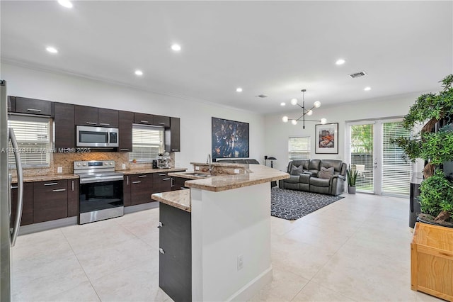 217 SW 11th St, Fort Lauderdale, FL 33315 - kitchen featuring stainless steel appliances, crown molding, backsplash, light tile patterned floors, and dark brown cabinets