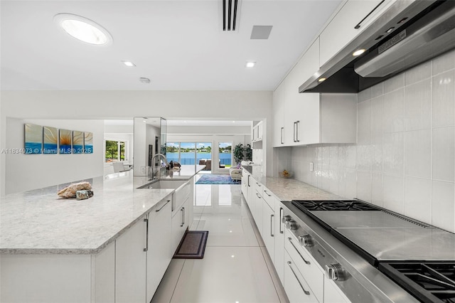 1930 NE 193rd St, Miami, FL 33179 - kitchen with ventilation hood, tasteful backsplash, white cabinetry, and recessed lighting