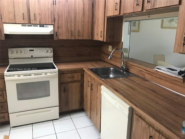 1101 Colony Point Cir Unit 206, Pembroke Pines, FL 33026 - kitchen featuring white appliances, under cabinet range hood, light tile patterned floors, and brown cabinets