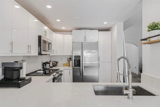 11532 SW 148th Path, Miami, FL 33196 - kitchen featuring appliances with stainless steel finishes, white cabinetry, tasteful backsplash, light stone counters, and recessed lighting